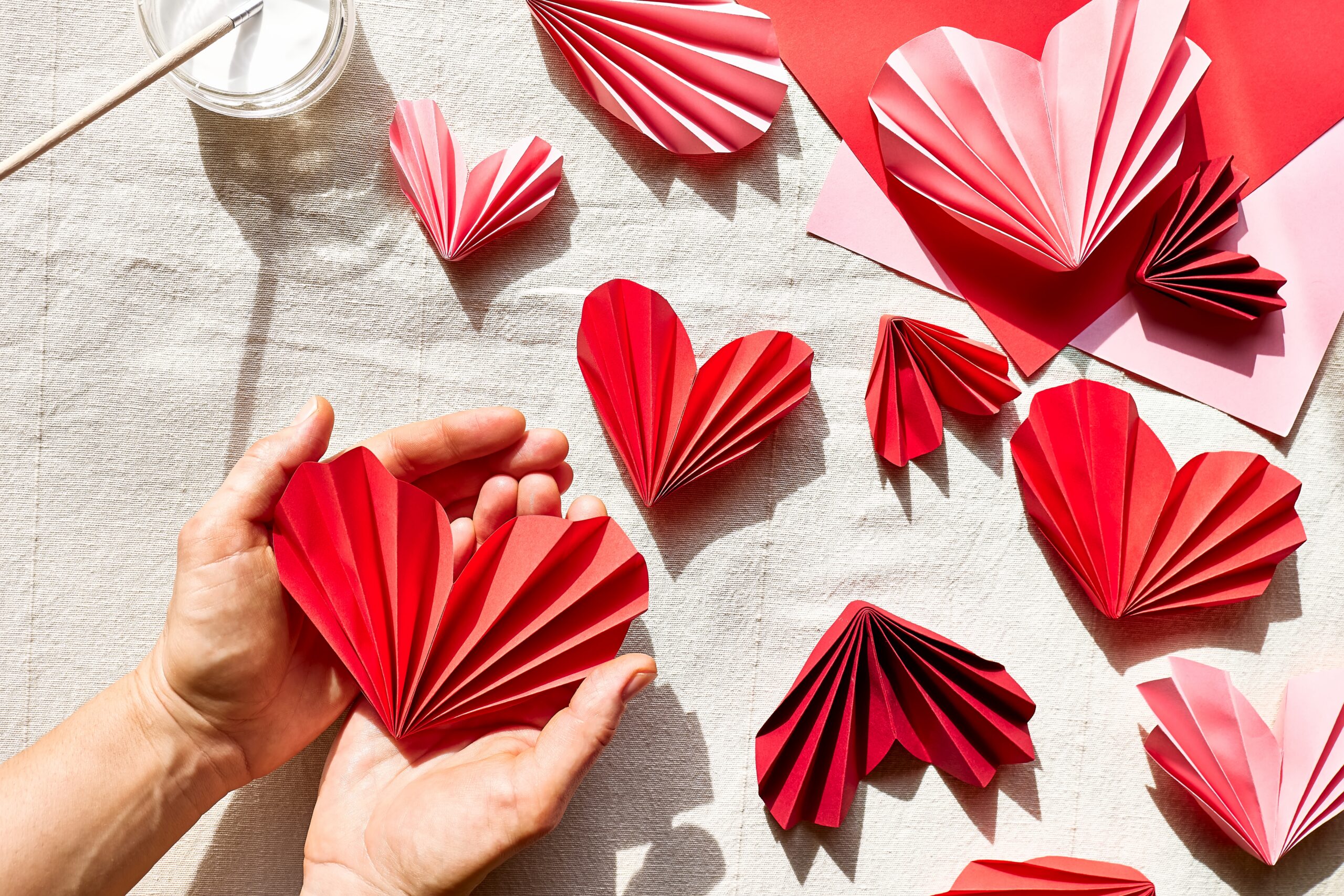 Woman,Hands,Making,Paper,Hearts.,Origami,Garland.,Symbol,Of,Love Woman,Hands,Making,Paper,Hearts.,Origami,Garland.,Symbol,Of,Love