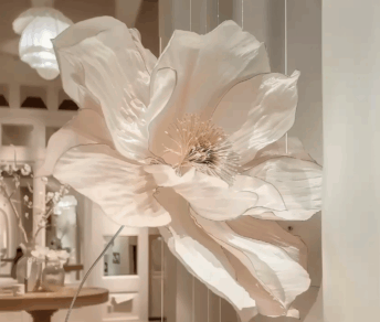 Large white floral sculpture suspended in a luxurious boutique interior, showcasing delicate petal details and modern decorative design for upscale retail ambiance